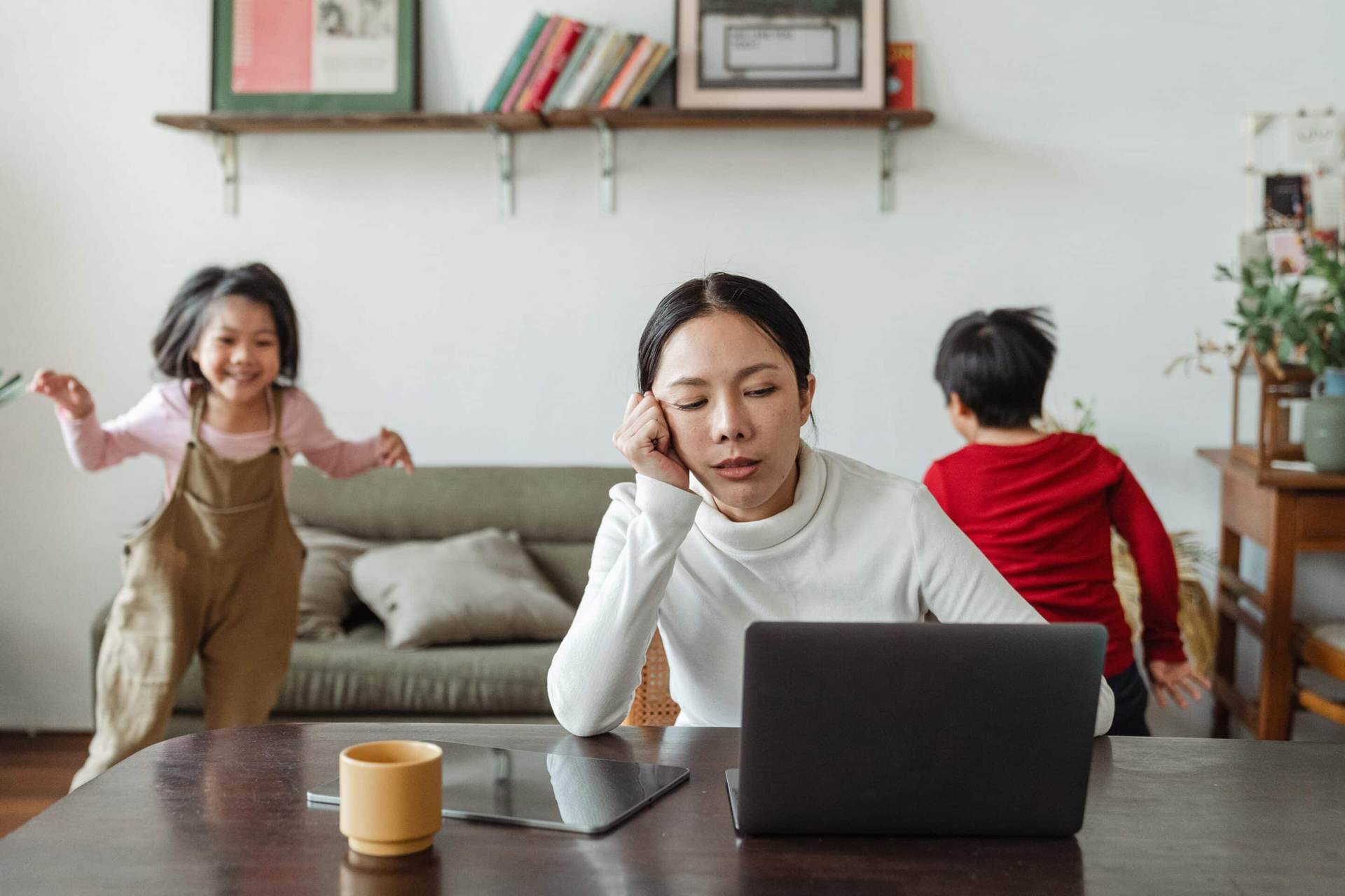 mom guilt while working with children playing in background